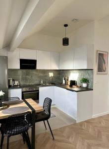 帕艾维坡斯特Magnifique Appartement Neuf, 5 Min Orly - Climatisé的厨房配有白色橱柜和桌椅