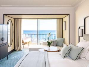 戛纳Mondrian Cannes的酒店客房设有一张床和一个大窗户