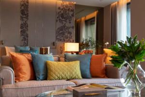 曼谷曼谷新通凯宾斯基酒店的客厅配有带色彩缤纷枕头的沙发