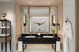 曼谷曼谷新通凯宾斯基酒店的浴室设有黑色水槽和镜子