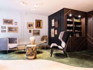 枫丹白露Aigle Noir Fontainebleau MGallery的客厅配有两把椅子和一张桌子
