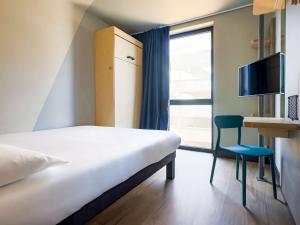 拉罗谢尔ibis Budget La Rochelle Centre的卧室配有床、椅子和窗户。
