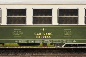 坎弗兰克埃斯塔西翁Canfranc Estación, a Royal Hideaway Hotel - Gran Lujo的轨道上的绿色和白色火车车厢