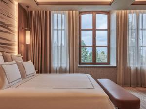 伯萨Swissotel Uludag Bursa的一间卧室设有一张大床和一个窗户。