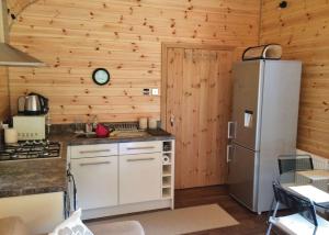 CaerwysHerons Lake Retreat的厨房设有木墙和冰箱。