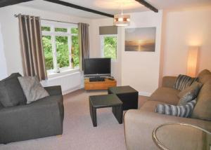 CaerwysHerons Lake Retreat的客厅配有2张沙发和1台平面电视