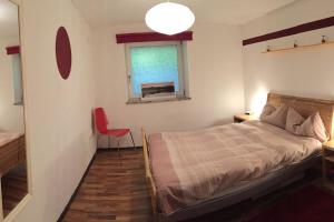 斯塔费顿Large 8 Bed Apartment. Perfect Location.的一间卧室设有床、窗户和红色椅子