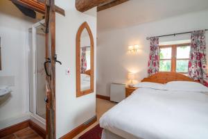 BuckinghamshireMill Cottage的卧室配有白色的床和镜子
