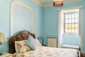 波亚里什新镇拱门9乡村民宿的一间卧室配有一张蓝色墙壁的床和一扇窗户
