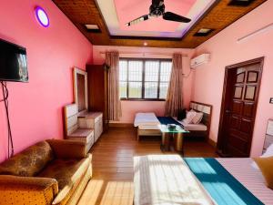 卡拉奇Karachi Inn的一间设有粉红色墙壁、一张沙发和一台电视机的客房