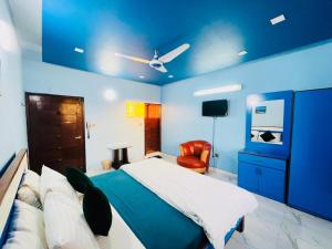 卡拉奇Karachi Inn的蓝色卧室,配有床和椅子
