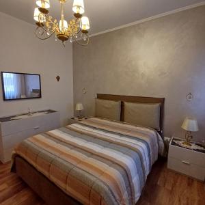 福贾NSM La Vie en Rose的一间卧室配有一张大床和一个吊灯。
