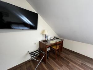 克莱佩达梅梅尔酒店 的客房设有书桌和墙上的电视。