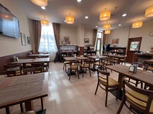 克莱佩达梅梅尔酒店 的一间带木桌和椅子以及钢琴的餐厅