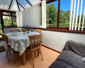 LlanllwchaiarnOld Stable Cottage Nanternis的用餐室配有带酒杯的桌子