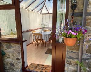 LlanllwchaiarnOld Stable Cottage Nanternis的温室,桌子和花盆