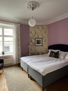 哥德堡DA Hotel Apartments的一间卧室设有一张紫色墙壁的大床