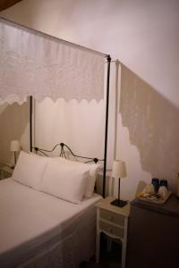 哈尔基岛Kleanthe的一间卧室配有一张带天蓬的白色床