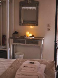 哈尔基岛Kleanthe的浴室设有一张带镜子和蜡烛的床