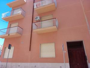 特拉帕尼Casa vacanze ferro的一座橙色的建筑,设有阳台和门
