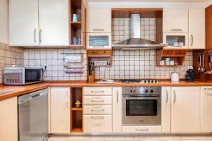 雅典艺术豪华别墅的厨房配有白色橱柜和不锈钢用具