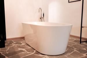 佐内贝克Vakantiewoning Domein Hooverbosch的浴室设有浴缸和水龙头