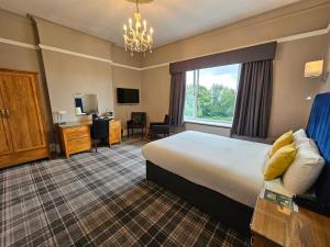 帕迪厄姆Burnley West Higher Trapp Hotel的配有一张床和一张书桌的酒店客房