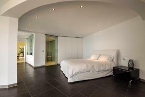 卡尼索Zula House - Stunning designer villa in spectacular location的卧室配有白色的床和黑色瓷砖地板。