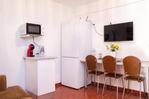 马希库GuestReady - Machico sea view residence - B的厨房配有白色冰箱、桌子和椅子