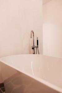 佐内贝克Vakantiewoning Domein Hooverbosch的浴室设有浴缸和水龙头
