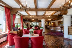 德布里阿赫布格斯塔勒法米丽恩谷特酒店的酒店大堂设有红色椅子和桌子