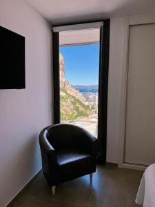 直布罗陀E1 Suites & Spa aparthotel style - Gym & Spa的一张黑椅,位于带大窗户的房间里