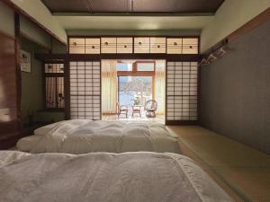 小樽小樽锦園的一间带床的卧室,位于带窗户的房间内