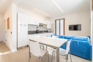 加尔达湖滨Residence Villa degli Aranci的厨房配有蓝色的沙发、桌子和椅子