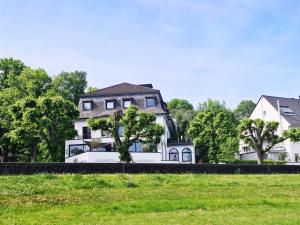 科隆莱茵布里克别墅酒店的一座大白房子,位于树木林立的田野中