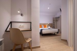 巴塞罗那三斯旅馆的一间卧室,卧室内配有一张床和一把椅子
