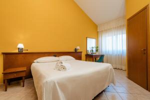 瓜尔迪亚格雷莱Hotel Altevie的卧室设有一张白色大床和黄色墙壁