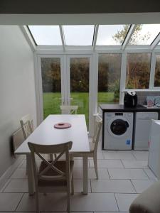 克利夫登Clifden Glen Cottage的厨房配有白色的桌椅和窗户。