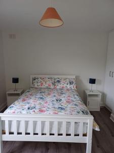 克利夫登Clifden Glen Cottage的卧室内的一张白色床,设有2个床头柜