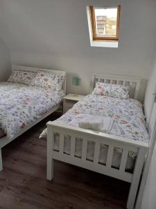 克利夫登Clifden Glen Cottage的一间卧室设有两张床和窗户。
