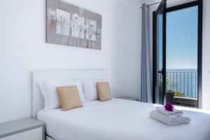 加乌拉GuestReady - Leme Beach Breathtaking Views的卧室配有白色的床和大窗户