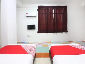 哥打巴鲁KB Rest Inn-Twin Single的红色窗帘间内的两张床