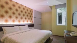 马六甲Riverfront Melaka Hotel的一间卧室设有一张大床和一个窗户。