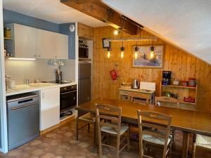 瓦卢瓦尔Appartement Valloire, 3 pièces, 5 personnes - FR-1-263-530的一间厨房,内设一张木桌和椅子