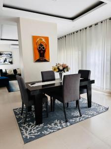 卢萨卡Kaya Apartments 2的一间用餐室,配有黑色的桌子和椅子
