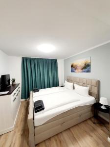 维斯马潘森奥普斯特尔酒店的卧室配有白色大床和绿色窗帘