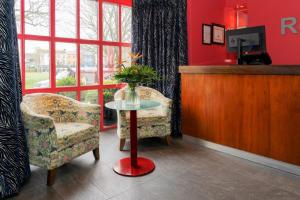 戈尔韦斯格芬顿亚姆斯酒店的一间设有两把椅子和一张带花瓶的桌子的房间