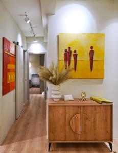 雅典P Faliro Riviera Suite的走廊上墙上有绘画作品,还有木柜