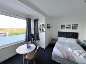 斯凯格内斯Harbour Flats的一间卧室配有一张床、一张桌子和一个窗户。