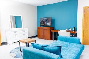 利隆圭Sigelege Boutique Hotel的客厅设有蓝色的墙壁、沙发和书桌